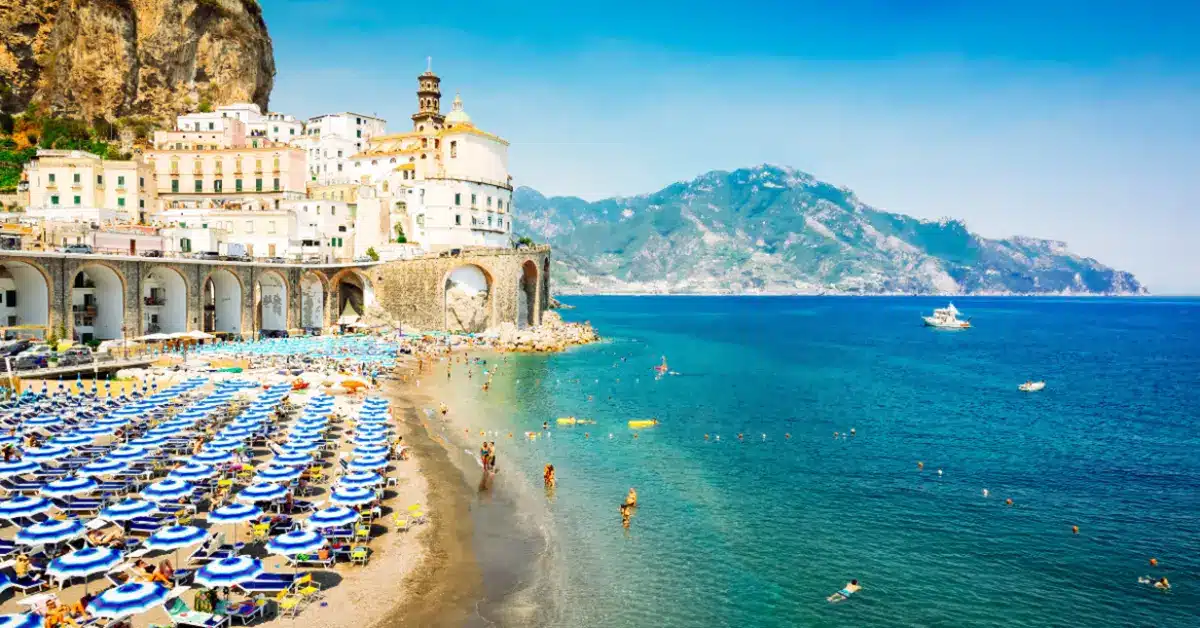 The busy beach of Atrani on the Amalfi Coast, a popular tourist destination offering high rental income potential for non-residents who buy a house in Italy.