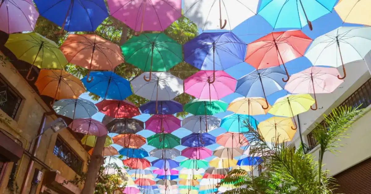A vibrant street decorated with colorful umbrellas in Southern Cyprus, illustrating the attractive lifestyle and non-domiciled tax benefits available to property owners.