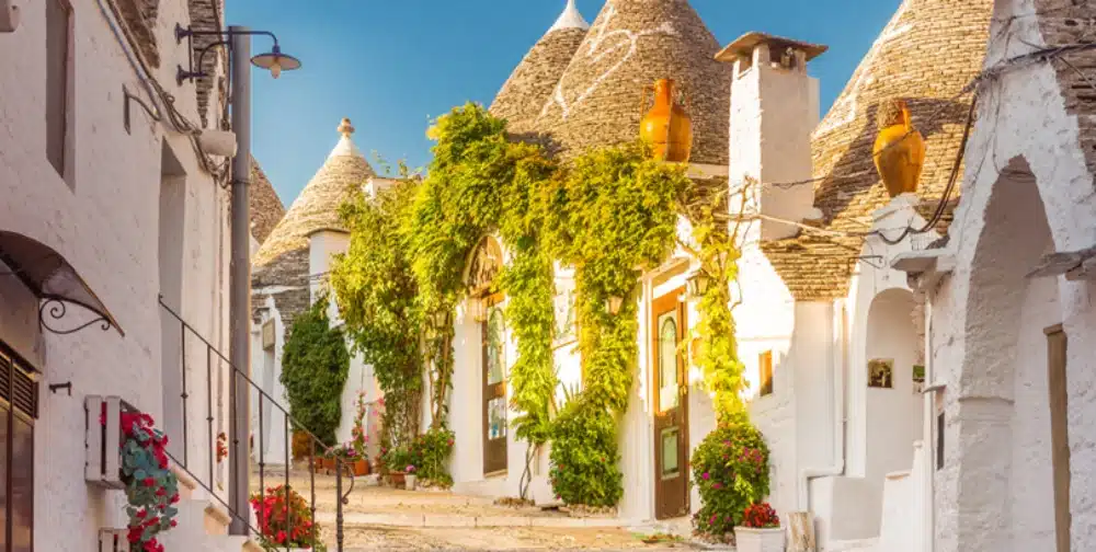 A charming street in Alberobello, Italy, with traditional Trulli houses, showcasing unique real estate opportunities for non-residents buying property in the Puglia region.