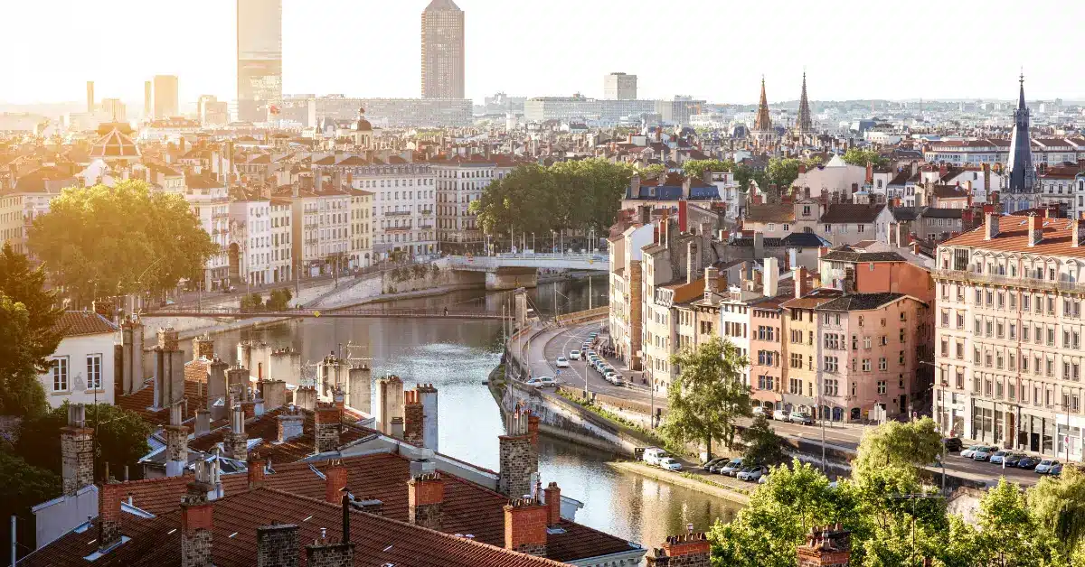 A scenic sunset over Lyon, a major city for buying property in france, showing the Saône river, bridges, and historic architecture.