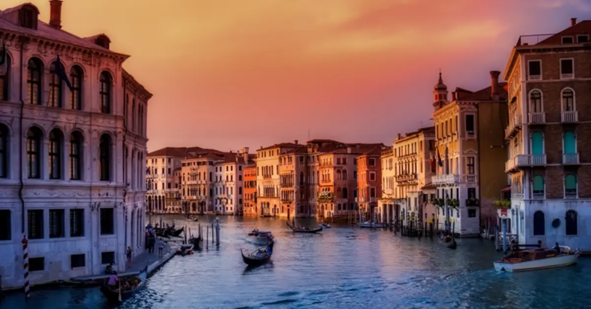 A beautiful sunset over a Venice canal with gondolas, highlighting mortgage options and the enduring appeal of real estate investment for ex-pats in Italy.